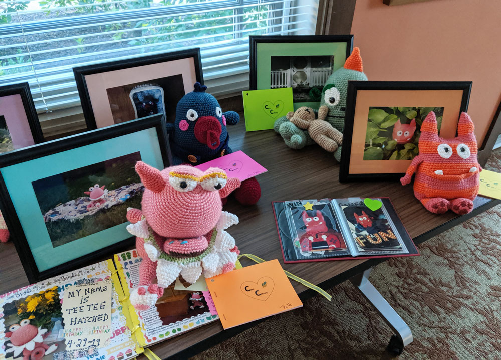 Caring Critters crochet monsters getting their photos and adoption certificates